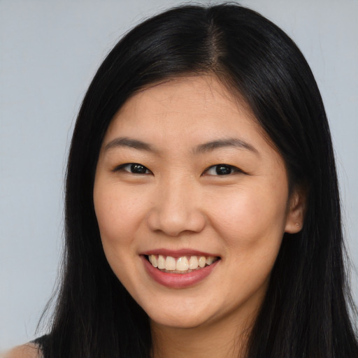 Joyful asian young-adult female with long  brown hair and brown eyes