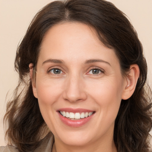 Joyful white adult female with medium  brown hair and brown eyes