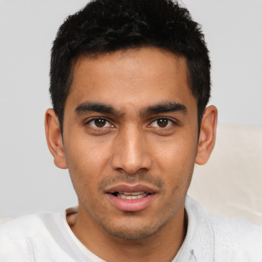 Joyful latino young-adult male with short  brown hair and brown eyes