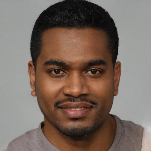 Joyful black young-adult male with short  black hair and brown eyes