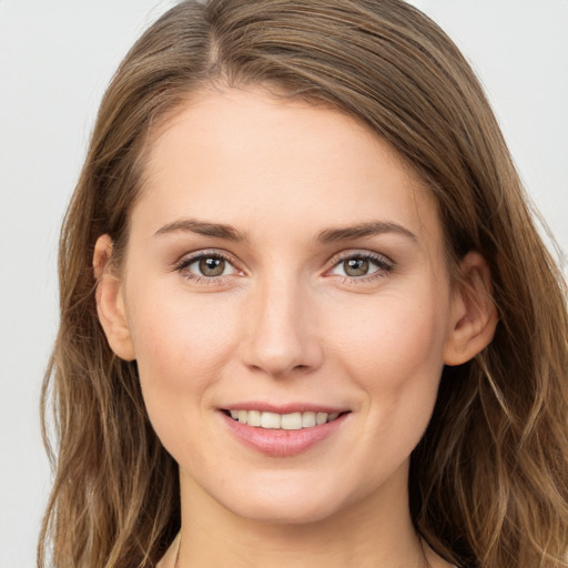 Joyful white young-adult female with long  brown hair and grey eyes