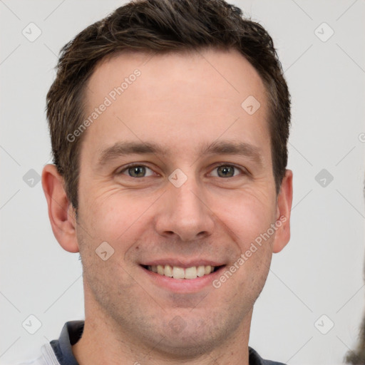 Joyful white young-adult male with short  brown hair and grey eyes