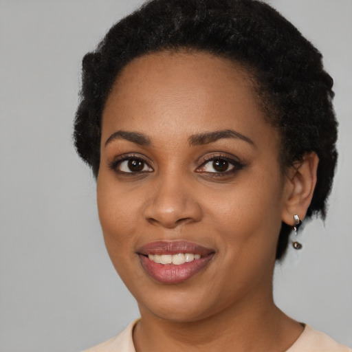 Joyful black young-adult female with short  black hair and brown eyes