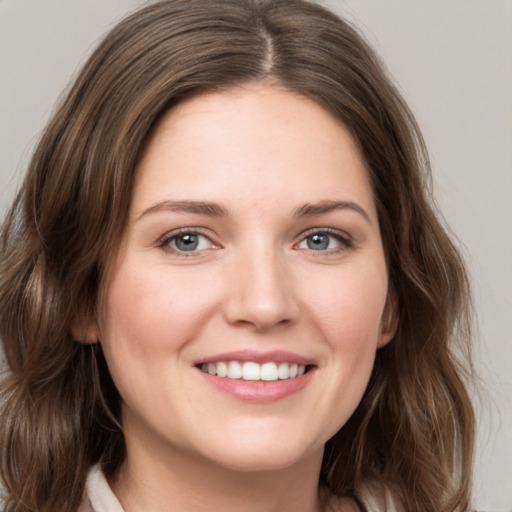 Joyful white young-adult female with medium  brown hair and green eyes