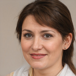 Joyful white adult female with medium  brown hair and brown eyes