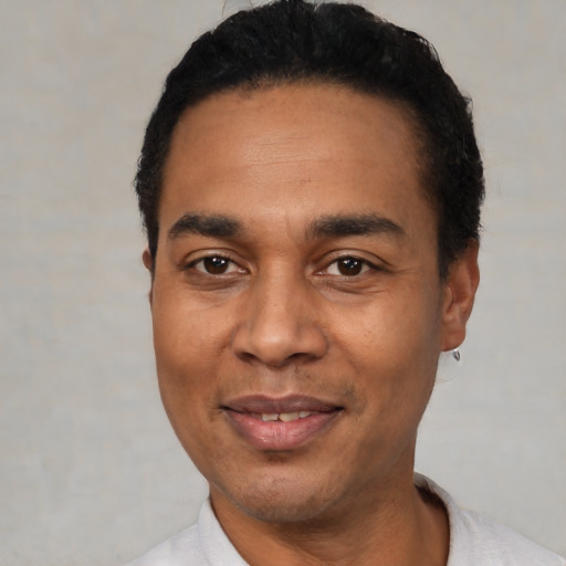 Joyful latino adult male with short  black hair and brown eyes