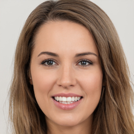 Joyful white young-adult female with long  brown hair and brown eyes