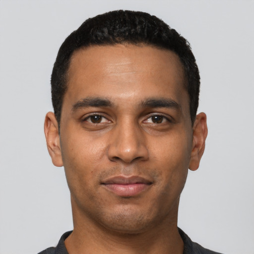 Joyful black young-adult male with short  black hair and brown eyes