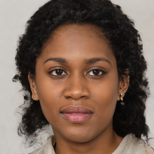 Joyful black young-adult female with long  black hair and brown eyes
