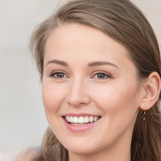 Joyful white young-adult female with long  brown hair and grey eyes