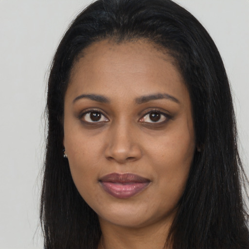 Joyful black young-adult female with long  brown hair and brown eyes