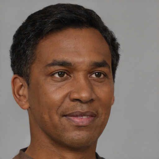 Joyful black adult male with short  black hair and brown eyes
