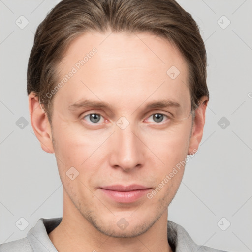 Joyful white young-adult male with short  brown hair and grey eyes