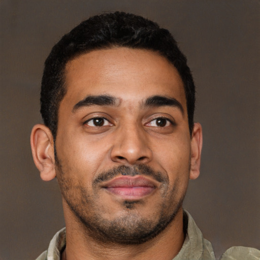 Joyful latino young-adult male with short  brown hair and brown eyes