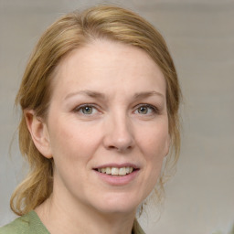 Joyful white adult female with medium  brown hair and blue eyes