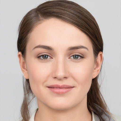 Joyful white young-adult female with long  brown hair and grey eyes