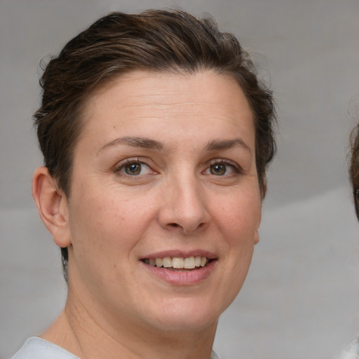 Joyful white adult female with short  brown hair and grey eyes