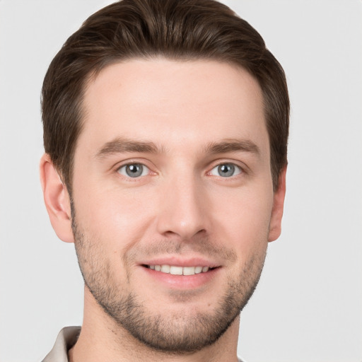 Joyful white young-adult male with short  brown hair and grey eyes