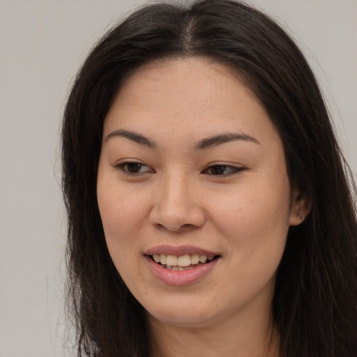 Joyful asian young-adult female with long  brown hair and brown eyes