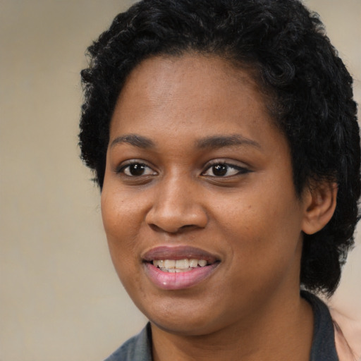 Joyful black young-adult female with long  black hair and brown eyes