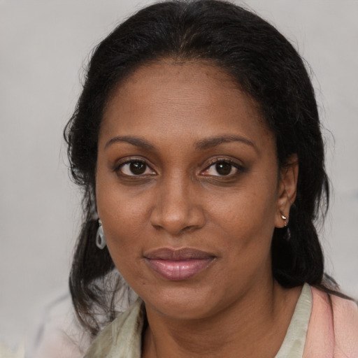 Joyful black adult female with medium  brown hair and brown eyes
