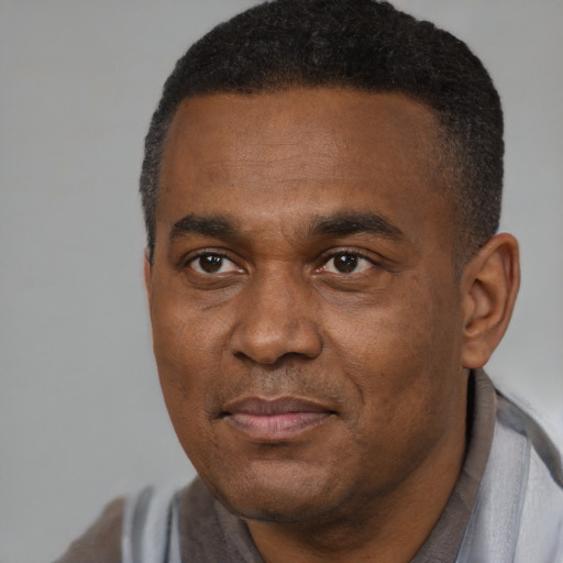 Joyful black adult male with short  black hair and brown eyes
