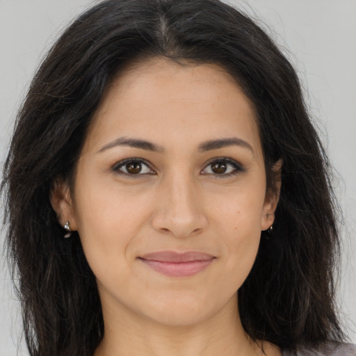 Joyful latino young-adult female with long  brown hair and brown eyes