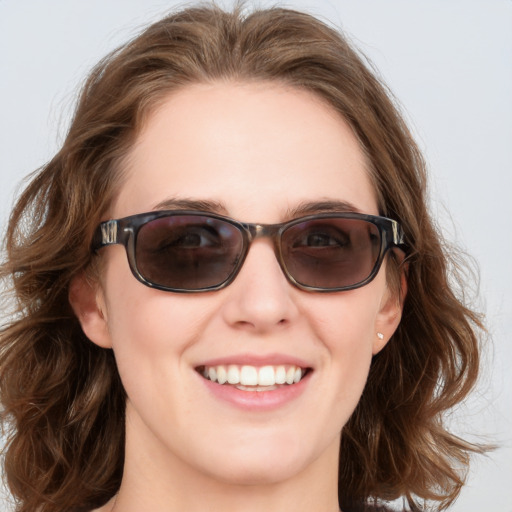 Joyful white young-adult female with medium  brown hair and blue eyes