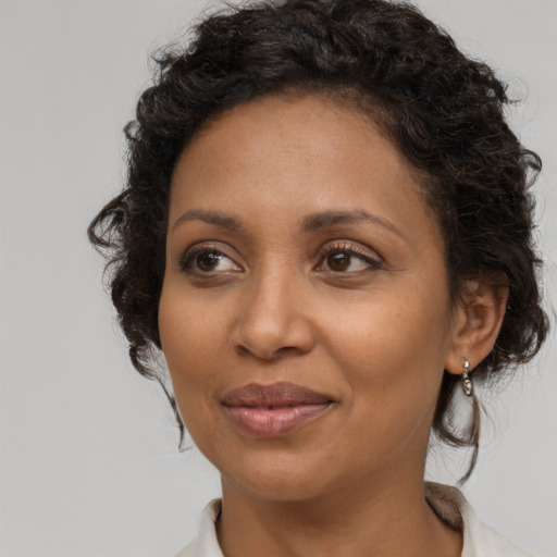 Joyful black adult female with medium  brown hair and brown eyes