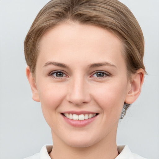 Joyful white young-adult female with medium  brown hair and grey eyes