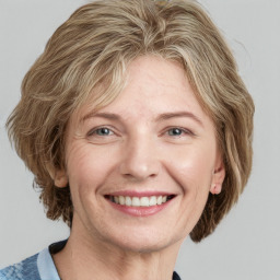 Joyful white adult female with medium  brown hair and blue eyes