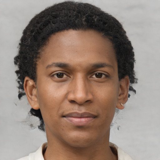 Joyful black young-adult male with short  brown hair and brown eyes