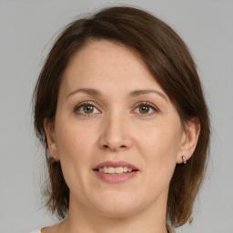 Joyful white young-adult female with medium  brown hair and green eyes