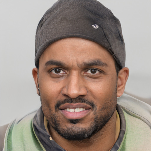 Joyful black young-adult male with short  black hair and brown eyes