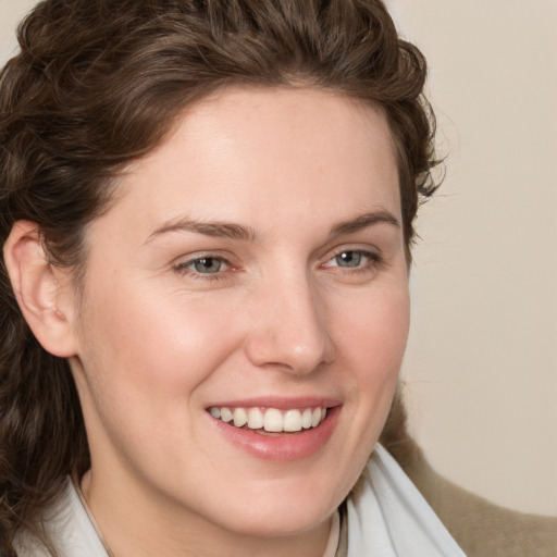 Joyful white young-adult female with medium  brown hair and blue eyes