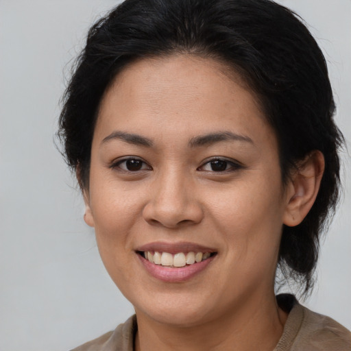 Joyful latino young-adult female with medium  brown hair and brown eyes