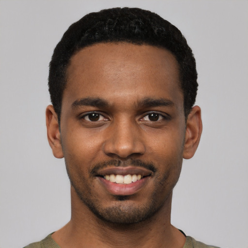 Joyful black young-adult male with short  black hair and brown eyes