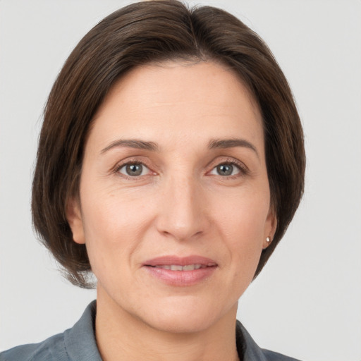 Joyful white adult female with medium  brown hair and grey eyes