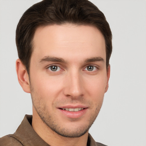 Joyful white young-adult male with short  brown hair and grey eyes