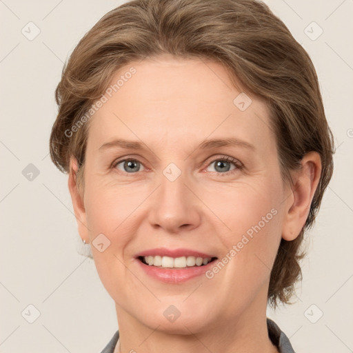 Joyful white adult female with medium  brown hair and grey eyes