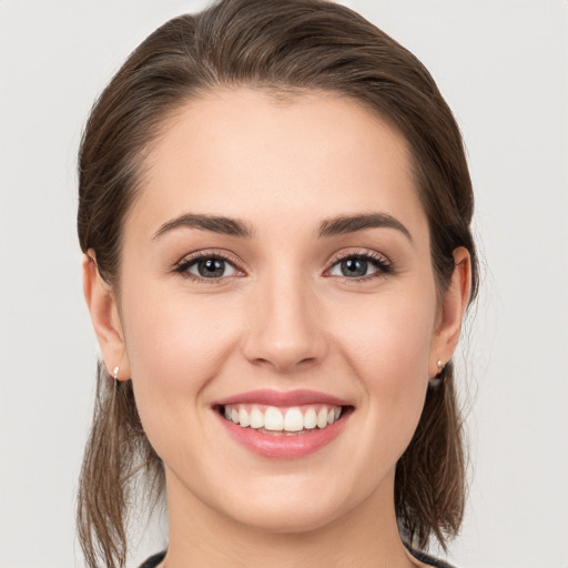 Joyful white young-adult female with medium  brown hair and grey eyes