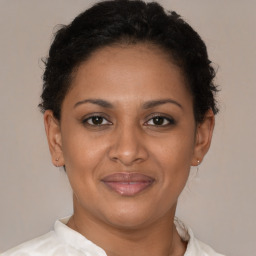 Joyful latino adult female with short  brown hair and brown eyes