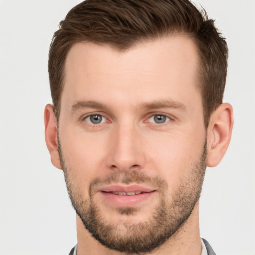 Joyful white young-adult male with short  brown hair and grey eyes