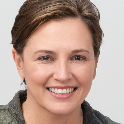 Joyful white young-adult female with medium  brown hair and grey eyes