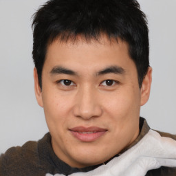 Joyful asian young-adult male with short  brown hair and brown eyes