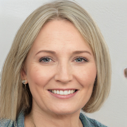 Joyful white adult female with medium  brown hair and grey eyes