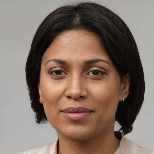 Joyful latino adult female with medium  brown hair and brown eyes