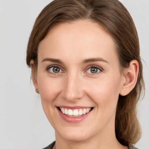 Joyful white young-adult female with medium  brown hair and grey eyes