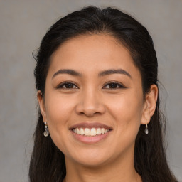 Joyful latino young-adult female with long  brown hair and brown eyes