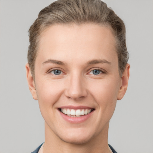 Joyful white young-adult female with short  brown hair and grey eyes